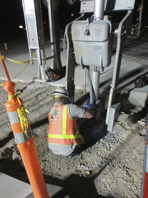 A construction worker is working on the sidewalk.