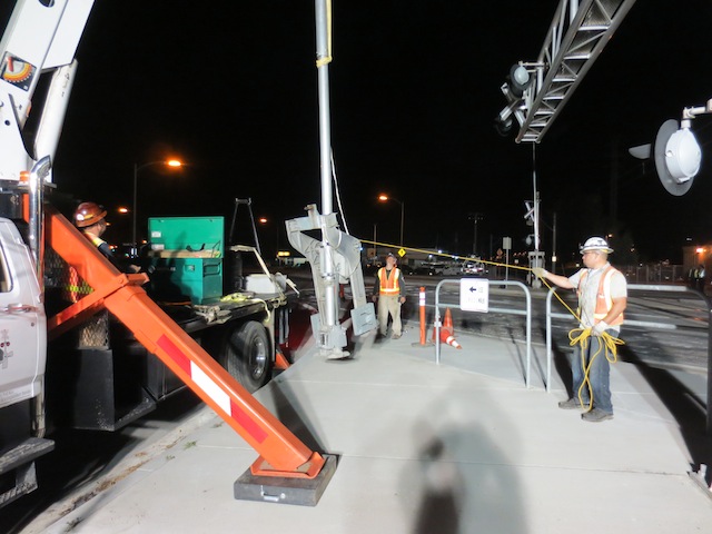 A group of construction workers standing around at night.